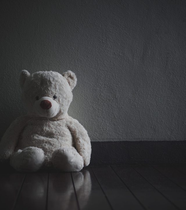 Lonely Teddy Bear Sitting in the dark room (Concept about love)